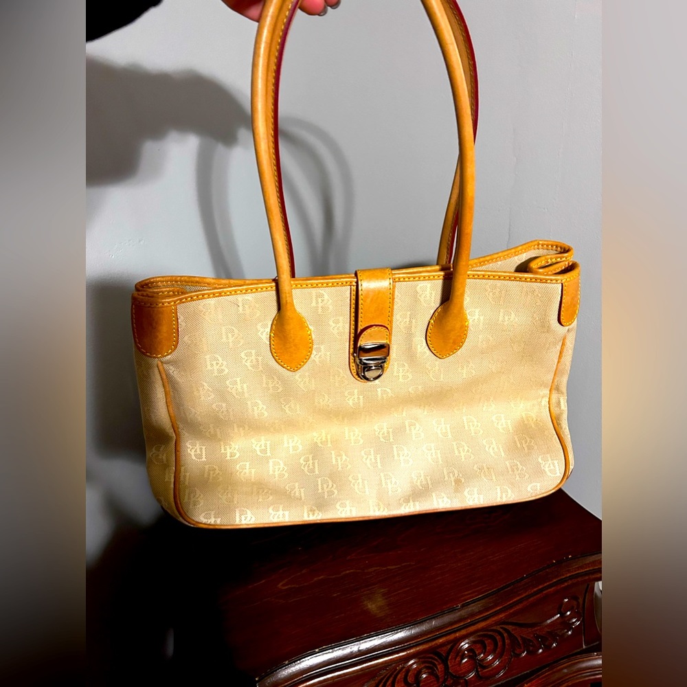 Great used Dooney and bourke monogrammed cream and patina handled tote